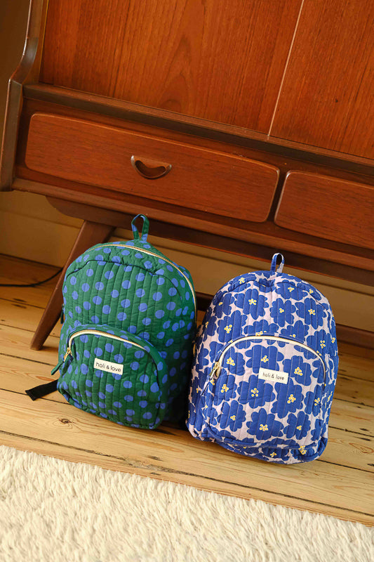 Deux sacs à dos côte à côte, l'un au motif dots et l'autre big flower, en coton matelassé. Accessoire enfant ou adulte idéal pour ranger toutes ses affaires d'école et de voyage.