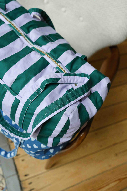 Détail du tissu et de la fermeture du sac weekend en coton imprimé stripes, rayures vert et violet. Sac de voyage et accessoire de mode pour femme en coton.
