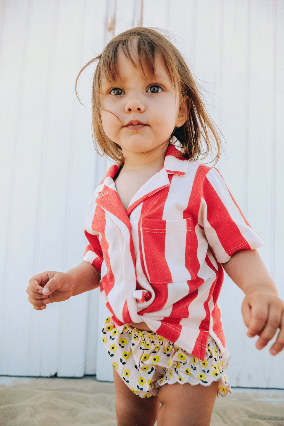 Bébé portant la chamise à manches courte ARI et le bloomer BETTY à motif petites fleurs jaunes vêtements en coton bio certifié GOTS style vintage mixte unisexe