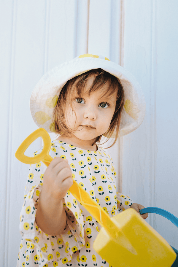 Bébé portant la blouse PIA imprimé petites fleurs jaunes, le bloomer BETTY motif citron et le BOB assorti, vêtements bébé en coton bio certifié GOTS style vintage mixte unisexe