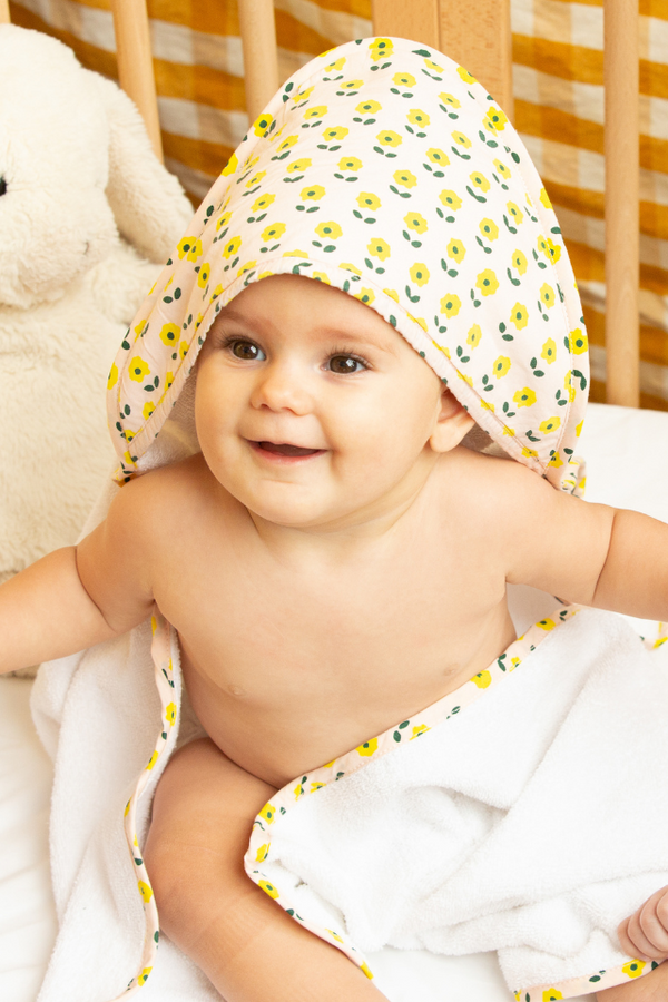Bébé mignon portant la cape de bain douce avec imprimé Flower, collection bébé naissance Baby Care en coton bio
