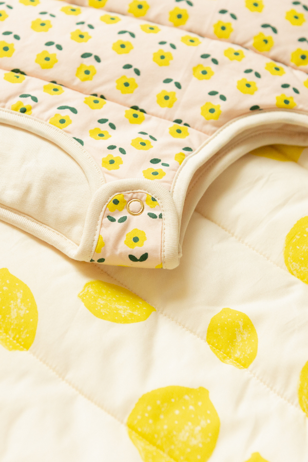 La gigoteuse Flower à plat sur la gigoteuse Lemon, collection bébé naissance Baby Care coton bio